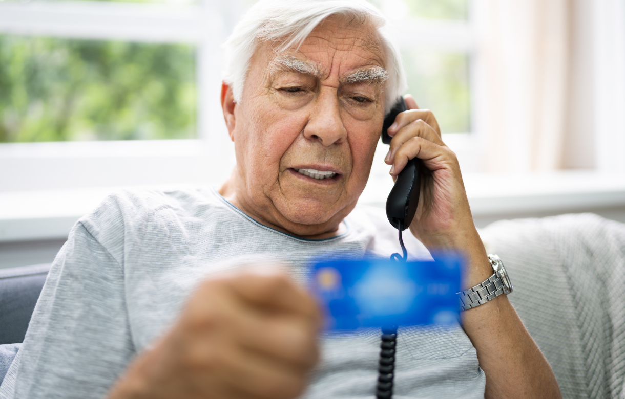 Man on phone reading debit card info